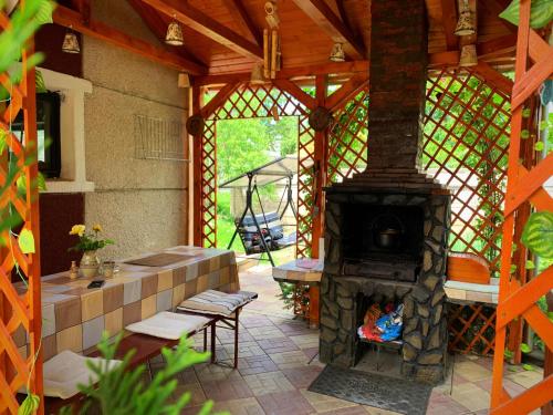 a patio with a fireplace and a table and chairs at Casa Mary in Haţeg