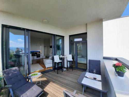 sala de estar con balcón con mesa y sillas en Lux -Luxury Sea and Mountains View Apartment-NEW en Koper