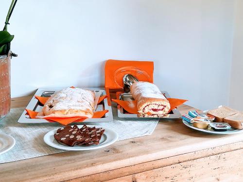 a table with three plates of sandwiches and desserts at B&B antico tabià dolomitico in Santo Stefano di Cadore