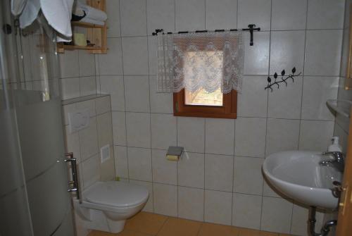 a bathroom with a toilet and a sink and a window at Schlintl-Hof in Liebenfels