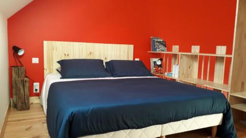 una camera con un grande letto con una parete rossa di LE RELAIS a Révillon