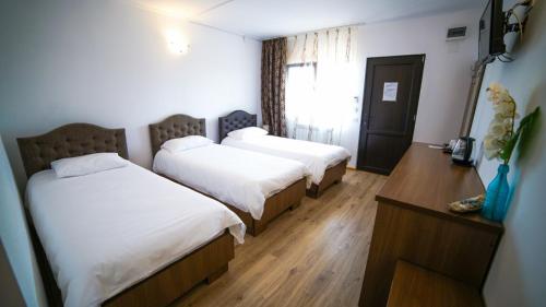 a hotel room with two beds and a table at Vila Natalia in Vama Veche