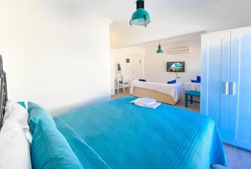 a blue bed in a white room with a bedroom at Nur Suites & Hotels in Kalkan