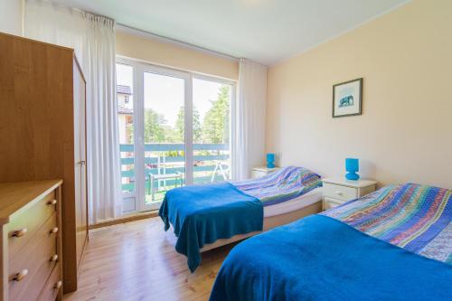 1 dormitorio con 2 camas y ventana grande en Villa LILIA, en Międzywodzie