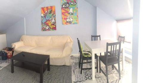 een woonkamer met een witte bank en een tafel bij 66 Peniche in Peniche