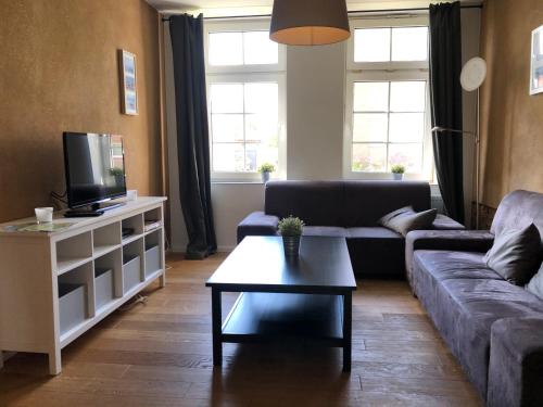 ein Wohnzimmer mit einem Sofa und einem Couchtisch in der Unterkunft Haus Meerliebe, Whg 1 in Cuxhaven