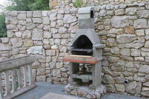 a stone oven sitting next to a stone wall at Primavera in Omišalj