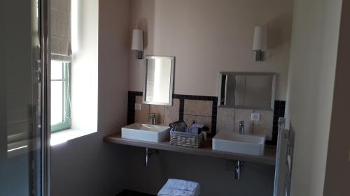 bagno con 2 lavandini e specchio di LE RELAIS a Révillon