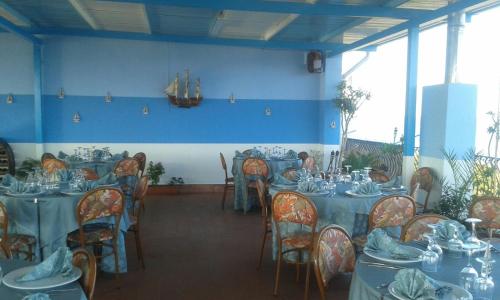 a dining room with tables and chairs with dishes on them at Hotel Panama in Ardore Marina