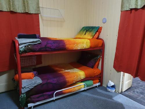 a room with two bunk beds with colorful blankets at Golden Mt Rest on James in Mount Morgan