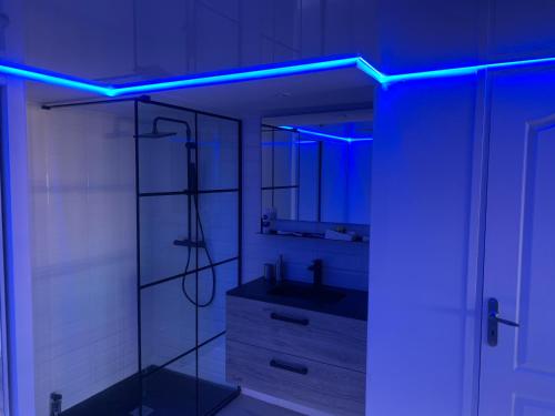 Un baño con lavabo y luz azul. en MARINA LOVE, en Cap d'Agde