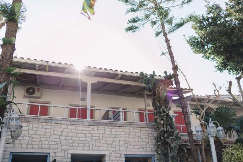 a building with a balcony with palm trees at Rouda Bay Beach Hotel in Mikros Gialos