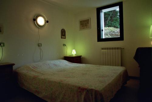 1 dormitorio con cama y ventana en B&B L'Intrigante, en Seborga