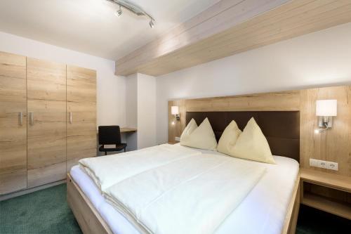 Schlafzimmer mit einem großen weißen Bett und einem Schreibtisch in der Unterkunft Haus Austria in Flachau