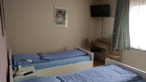 ein Krankenhauszimmer mit 2 Betten und einem Schreibtisch in der Unterkunft Apartment Zur Kogge in Wilhelmshaven