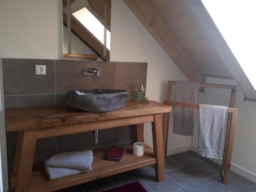 y baño con lavabo sobre una mesa de madera. en Ferienwohnung Geyer en Rennertshofen