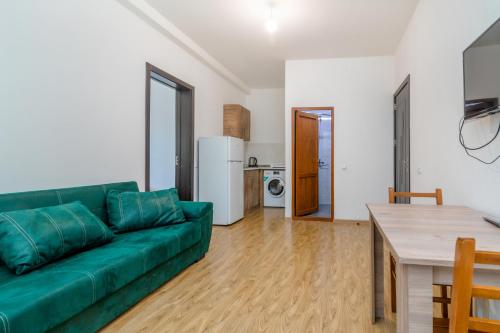 a living room with a green couch and a table at Hotel Continental in Gori