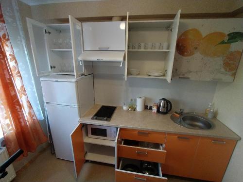 a small kitchen with a sink and a refrigerator at Rojas street apartments in Liepāja