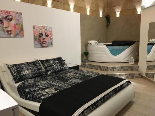 een slaapkamer met een bed en een bad bij La casetta di viale Paradiso in Pachino