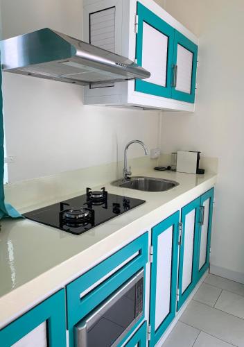 a kitchen with blue cabinets and a sink at Abiki Mauritius with Tourism Authority Permit in Albion