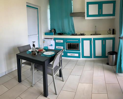 a kitchen with blue cabinets and a table and chairs at Abiki Mauritius with Tourism Authority Permit in Albion