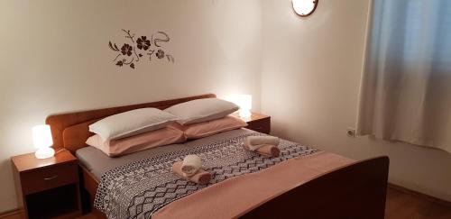 a bedroom with a bed with two pillows and shoes on it at Apartments Barac in Poreč