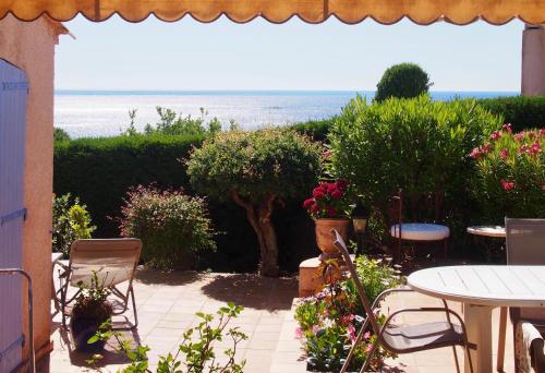 a patio with a table and chairs and the ocean at Villa Riviera, Sea view, Pool, Jacuzzi, Sauna, Walk to the beach in Sainte-Maxime