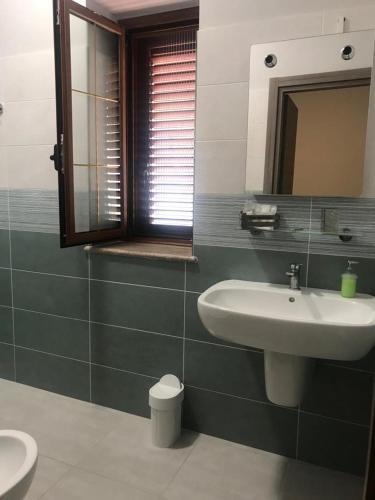 a bathroom with a sink and a mirror at AFFITTACAMERE BORGATA MARINA in Roseto Capo Spulico
