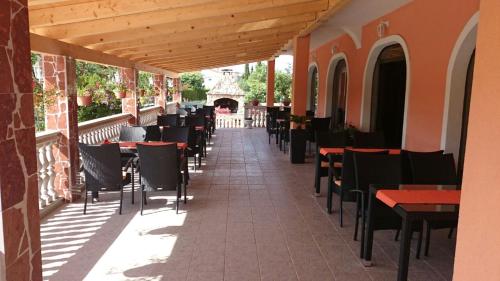 patio restauracji ze stołami i krzesłami w obiekcie VILLA NIKOLINA w Medulinie