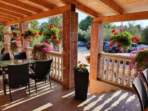 patio z krzesłami i kwiatami na balkonie w obiekcie VILLA NIKOLINA w Medulinie