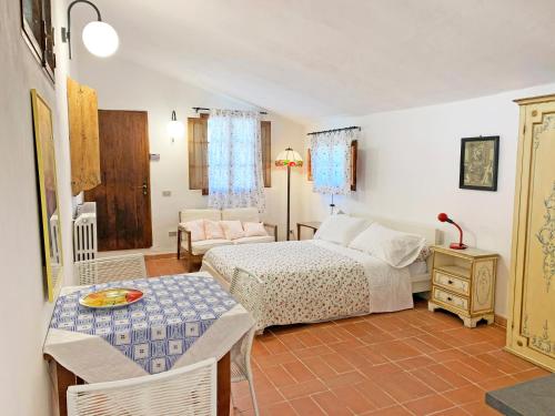 ein Schlafzimmer mit einem Bett, einem Tisch und einem Sofa in der Unterkunft S.M. IL CASTRO in Monteriggioni