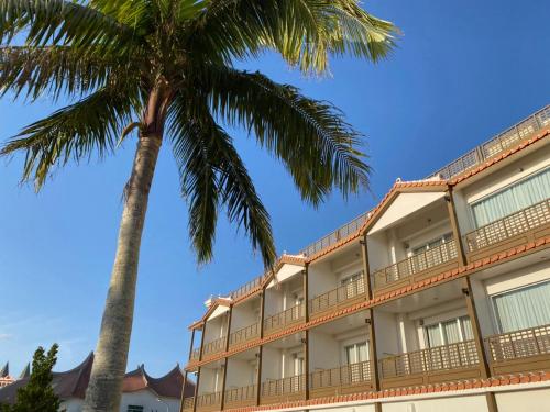 un hotel con palmeras en primer plano en サンセットビーチホテル, en Chatan