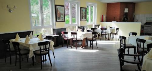 a restaurant with white tables and chairs and windows at Landhotel Schuff in Kindsbach