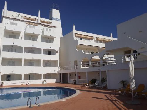 a hotel with a swimming pool in front of a building at venha nadar a oura in Albufeira