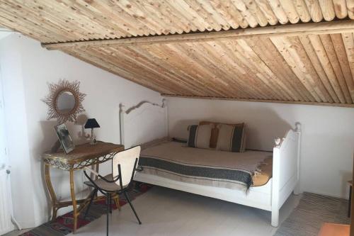 een slaapkamer met een bed en een houten plafond bij GITE COCOTTE LUBERON, FORCALQUIER in Pierrerue