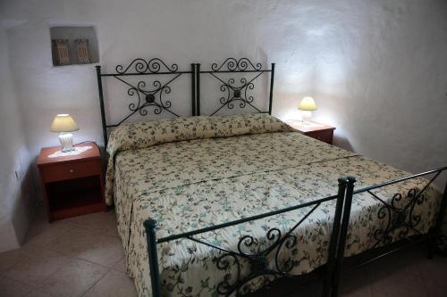 マルティナ・フランカにあるAgriturismo Masseria Casedde Vecchieのベッドルーム(ナイトスタンド2つ、ランプ2つ付)のベッド1台