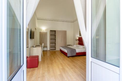 パレルモにあるBelmonte102 Esclusive Suitesの小さなベッドルーム(ベッド1台、赤い椅子付)