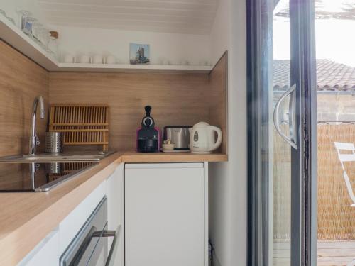 una cocina con armarios blancos y una ventana en Arles sous les toits - Terrasse proche des arènes en Arlés