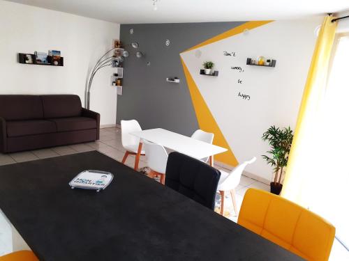 un salon avec une table, des chaises et un canapé dans l'établissement (-; Eldorado Saint-Jacques au nord de Toulouse ;-), à Saint-Alban