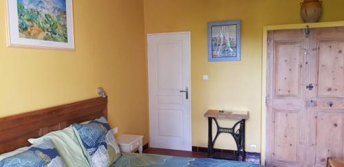 a bedroom with a bed and a door and a table at Les Tournesols in Mallemort