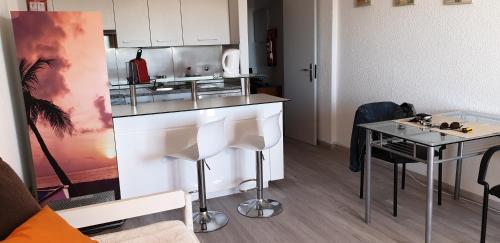 a kitchen with a counter and a table at Apartment Qiu in Costa da Caparica