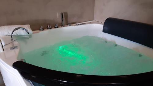 een badkamer met een bad gevuld met groen water bij La casetta di viale Paradiso in Pachino