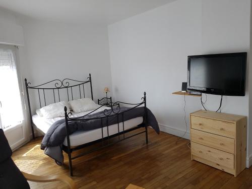 une chambre avec un lit et une télévision à écran plat dans l'établissement Franglais Flats, à Boulogne-sur-Mer