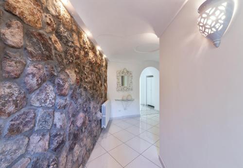 a room with a stone wall and a hallway at Villa dei Lecci - 7 Luxury villas with private pool or jacuzzi in Ischia