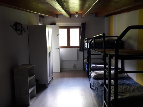 a room with three bunk beds and a window at Albergue Casa Txakainlo in Lesaka
