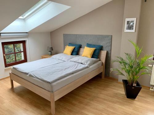 a bedroom with a large bed with blue and yellow pillows at Charmante Dachgeschoss Wohnung in Leipzig