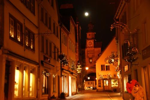 Eine Frau, die nachts die Straße entlang läuft in der Unterkunft Hotel Sonne - Das kleine Altstadt Hotel in Rothenburg ob der Tauber