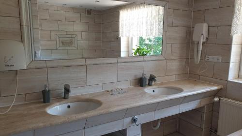 a bathroom with two sinks and a mirror at Villa Maniszewo in Serbów