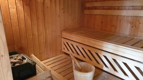 an empty wooden sauna with a bucket in it at Villa Maniszewo in Serbów