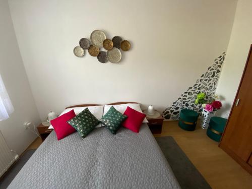 a bedroom with a bed with red and green pillows at Apartments Monty Podhájska in Podhájska